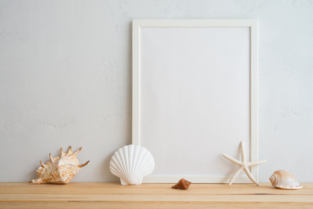 Summer beach holiday vacation concept, photo frame and seashell decoration mockup with white wall backgroundの写真素材