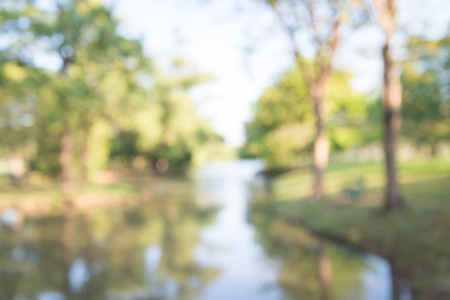 Blur of lake in city park bokeh background in summer, green nature conceptの写真素材