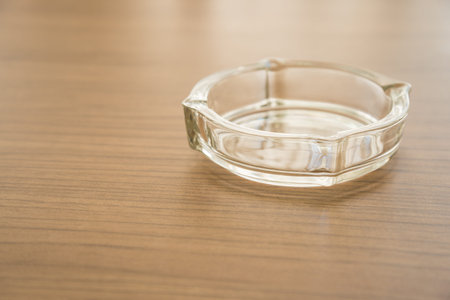 Empty glass ashtray on wooden tableの写真素材