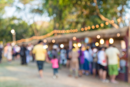 Blurred image of people in day market festival in city park backgroundの写真素材
