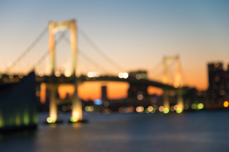 Defocused rainbow bridge cityscape in twilight evening bokeh background, Odaiba Tokyo Japanの写真素材
