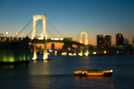 Defocused rainbow bridge cityscape in twilight evening bokeh background, Odaiba Tokyo Japanの写真素材