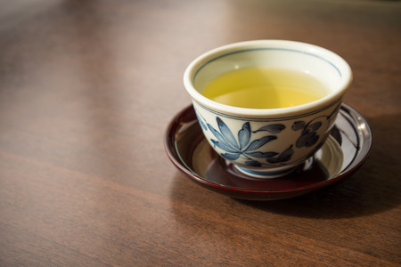 A ceramic cup of traditional Japanese tea on wooden tableの写真素材