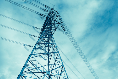 Electricity post high power at low angle view - Monochrome blue technology toneの写真素材