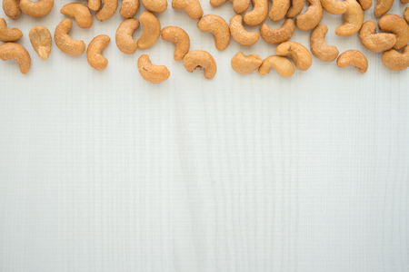 Salted cashew nuts on white wooden table with copy spaceの写真素材