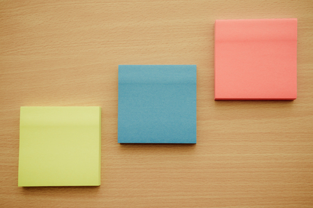 Color block of paper notes on wood table - Retro filter effectの写真素材