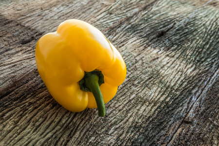 Yellow sweet pepper on old wooden backgroundの写真素材