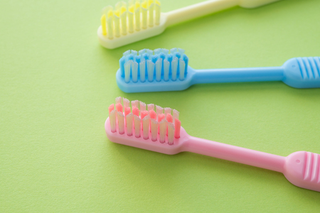 Colorful toothbrush on green background, dental care conceptの写真素材