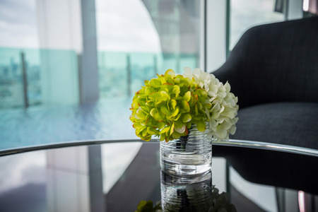 Fabric flower in clear glass jar at hotel lobby beside sky swimming poolの写真素材