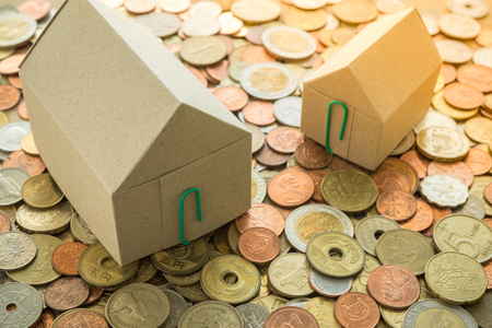 Recycle paper house on heap of vary country coins background - ideas house real estate conceptの写真素材