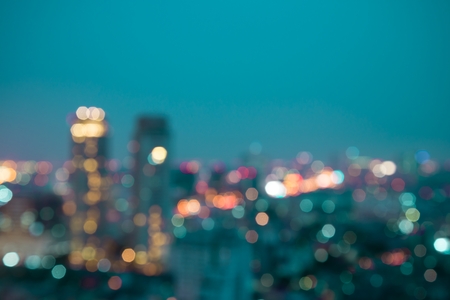 Defocused modern cityscape at night light background, blur urban skyscraper landscape twilightの写真素材