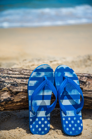Blue beach flip flops on tropical sand Thailandの写真素材