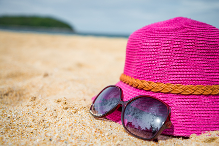 Pink hat and sunglasses on tropical beach in Thailandの写真素材