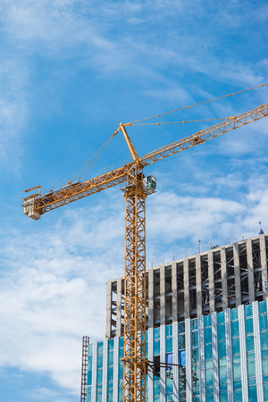 Crane and modern building construction site in Thailandの写真素材