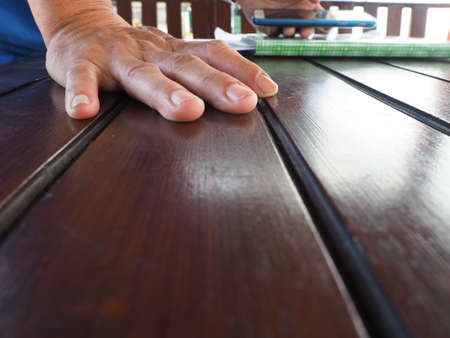 hand on brown wooden tableの写真素材