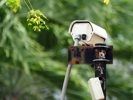 CCTV camera on rusty pole in garden to guard residentの写真素材