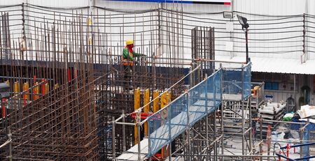 a worker with full seafty set in construction place and many steel wire structureの写真素材