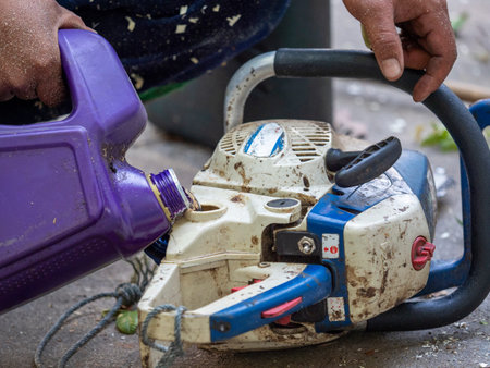 worker fill fuel to chainsaw after work