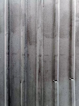 An aged, corrugated metal surface exudes weathered and industrial feel, hinting at years of exposure and resilienceの写真素材