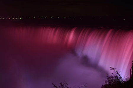 Colorful illuminated Niagara Falls at night in Ontario, Canada