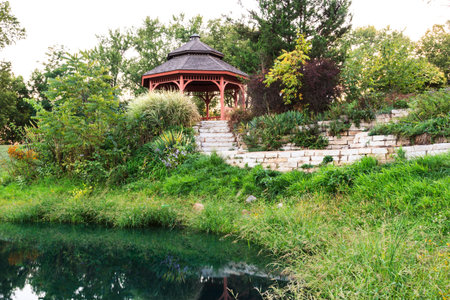 Secluded garden gazebo reflected in the water