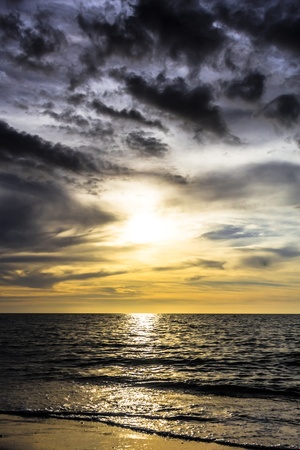 dramatic dark cloudy sunset over the ocean and beachの写真素材