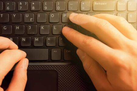 Hands on computer keyboard. Film effect, flare sunの写真素材