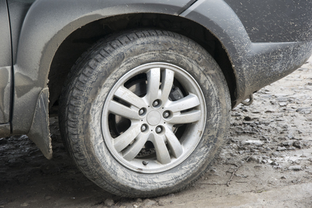 Dirty car wheel closeup. Vechicle tire in mudの写真素材