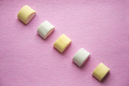 Top view of pastel colored marshmallow on beautiful pink background. Wallpaper texture.の写真素材