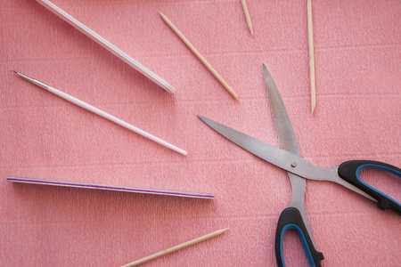 Set of files and woodern sticks for manicure or pedicure procedure with scissors on pink background.の写真素材