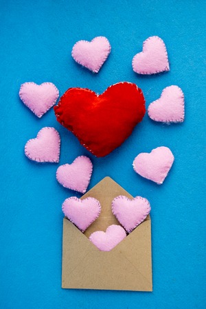 Romantic letter: craft paper envelope open with hearts flying out. Concept of wedding or Valentines Day.の写真素材