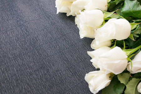 Beautiful white roses on rustic wooden background with copy space.