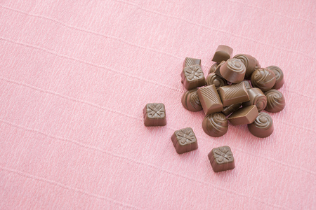 Chocolates set pile placed on pink backgroundの写真素材