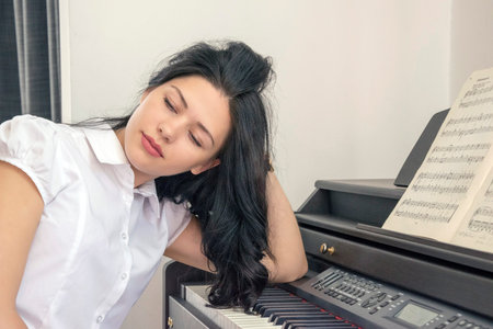 Woman sitting near a synthesizer and dreaming