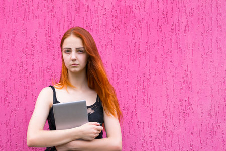 Portrait of redhead girl holding tablet pc
