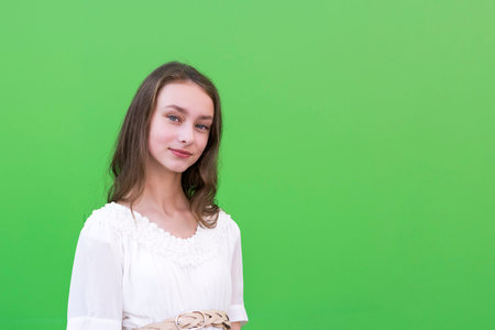 Young charming female on green wallの写真素材