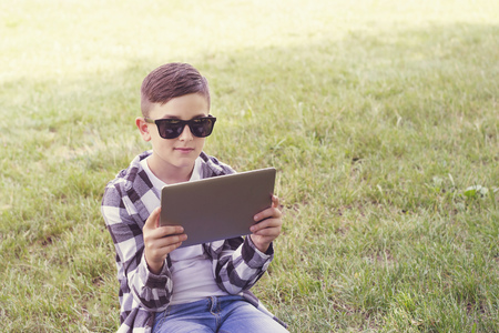 Young guy with stylish haircut using tablet pcの写真素材