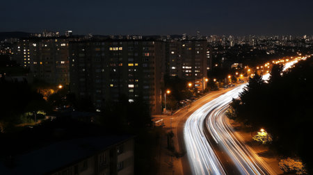 Blurred motion effect of a highway with streaks of car lights, conveying high-speed movement against a nighttime cityscapeの素材