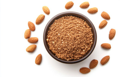 A bowl of almond butter with whole almonds around it on a white background, showcasing the creamy texture and nutty flavor of the spread.の素材