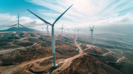 Aerial view of wind turbines in a desert landscape, capturing the stark beauty and vastness of renewable energy infrastructure.の素材