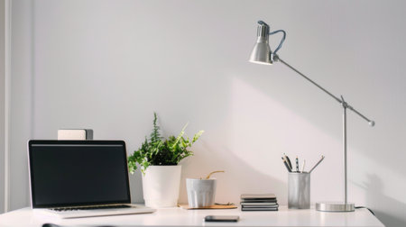 A minimalist workspace with bright, focused task lighting illuminating a clean and organized desk areaの素材
