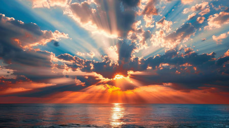 Beams of light breaking through the clouds during a breathtaking sunset over the oceanの素材