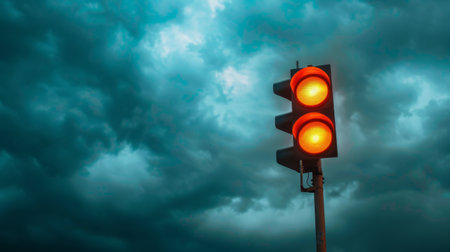 A traffic light against a dramatic cloudy sky, symbolizing weather conditions affecting trafficの素材