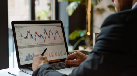 A financial advisor explaining a graph to a client, using a laptop to illustrate market trends and predictions.の素材
