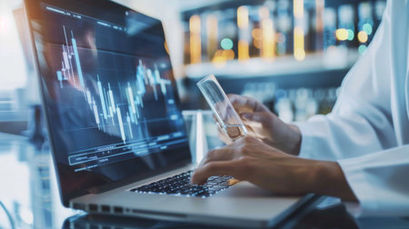 A scientist analyzing a graph on a laptop, focusing on research data and experimental results.の素材