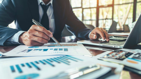 A financial consultant reviewing a client's investment goals and strategies, using a mix of digital tools and printed materials.の素材