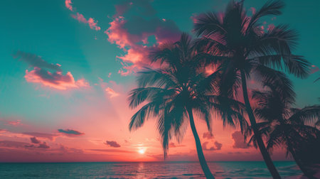 Silhouettes of palm trees against a stunning sunset sky at a tropical beach, creating a peaceful and serene atmosphere.の素材