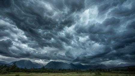 Dramatic storm clouds gathering ominously over a mountain range in the distance.の素材