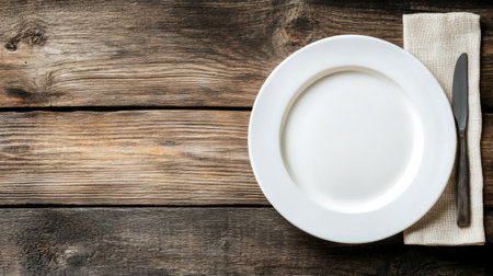 A clean white plate on a rustic wooden table, leaving ample copy space for text.の素材