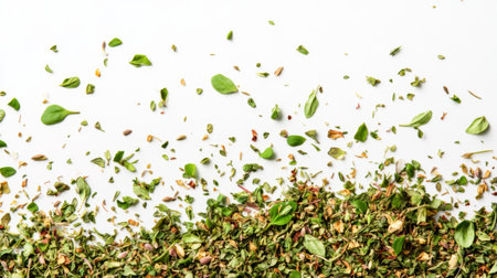 A close-up of dried herbs such as oregano, thyme, and parsley scattered across a white background, showcasing their textures.の素材